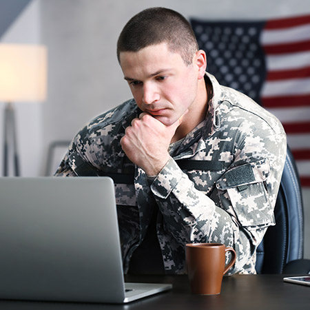 Military member looking at laptop