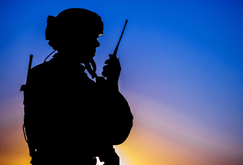 A silhouette of a soldier with a radio.